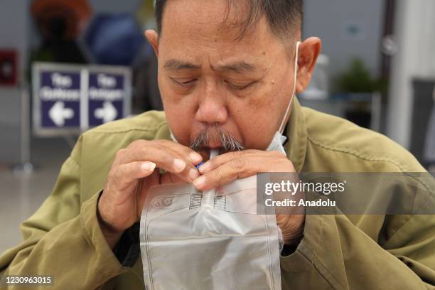 Traveler exhales breath in a breath bag to be tested with GeNose C19 at Pasar Senen Station, Jakarta, on January 2021. Now travelers who use train...