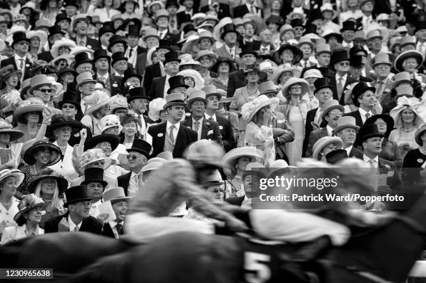 Spectators at the Royal Ascot horse race meeting watch the finish of a race, Berkshire, England, circa July 1976. This image is from a series of...