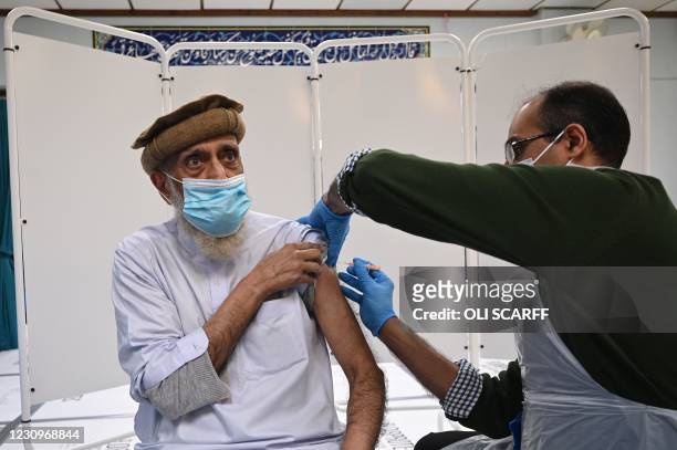 Pharmacist, Murtaza Abdulkarim administers a dose of the AstraZeneca/Oxford Covid-19 vaccine to a patient at a temporary vaccination centre, staffed...