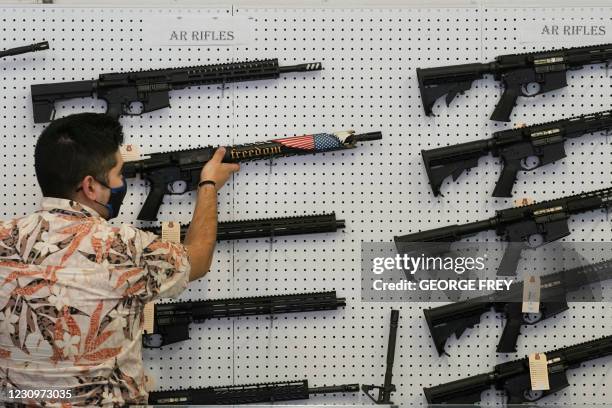 Worker hangs a custom made AR-15 style rifle on a wall at Davidson Defense in Orem, Utah on February 4, 2021. - Gun merchants sold more than 2...