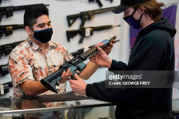 Customer looks at a custom made AR-15 style rifle at Davidson Defense in Orem, Utah on February 4, 2021. - Gun merchants sold more than 2 million...