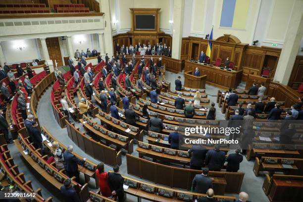 Lawmakers stand as they honor the memory of the medical workers who died fighting Covid-19 by standing up during the session of the Parliament in...