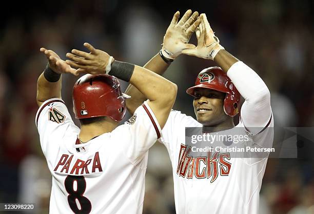 Justin Upton of the Arizona Diamondbacks high-fives Gerardo Parra after Upton hit a two run home against the Colorado Rockies during the eighth...