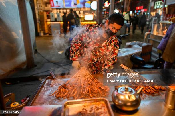 Food seller waits for clients at a market in Wuhan, China's central Hubei province on February 5, 2021.