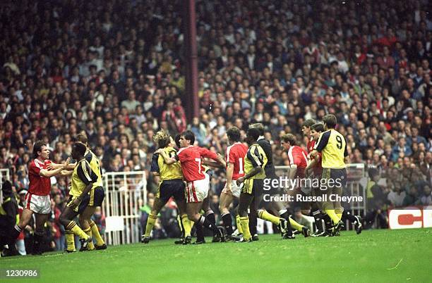 Manchester United and Arsenal players fight on the pitch during the Barclays League Division One match at Old Trafford in Manchester, England....