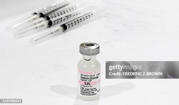Vial of Sodium Chloride for diluting the Covid-19 vaccine is seen in preparation for vaccinations on the opening day of a large-scale Covid-19...