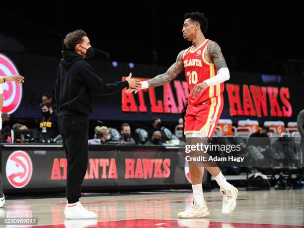 Trae Young of the Atlanta Hawks high fives John Collins during the game against the Utah Jazz on February 4, 2021 at State Farm Arena in Atlanta,...