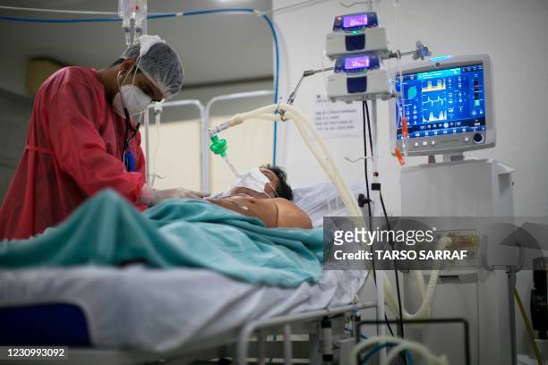 Patient receives treatment in a hospital bed in Oriximina, state of Para, Brazil on February 5, 2021. - Two hospital boats, the Pope Francis and the...