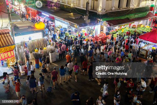 People cross a busy junction in Chinatown on February 6, 2021 in Singapore. The Chinese diaspora of Southeast Asia is celebrating a somewhat subdued...