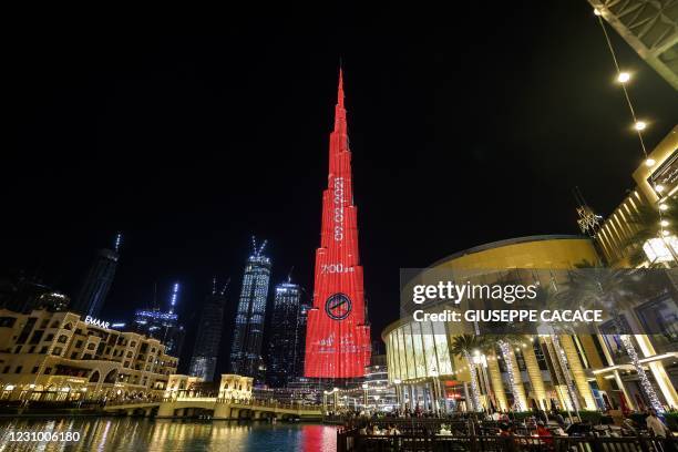 This picture taken on February 6, 2021 shows a view of Dubai's Burj Khalifa, the world's tallest skyscraper, lit red and showing a countdown to...
