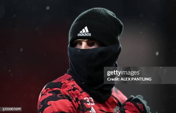 Manchester United's English defender Brandon Williams warms up for the English Premier League football match between Manchester United and Everton at...