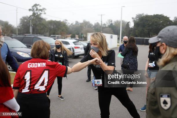 Commissioner Roger Goodells wife Jane Skinner and Congresswoman Kathy Castor fist bump before handing out food to families in need at Carter G....