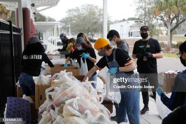 Volunteers for Feeding Tampa Bay help bag and handout food to families at Carter G. Woodson K-8 School in Tampa on February 6 in Tampa, Florida. NFL...