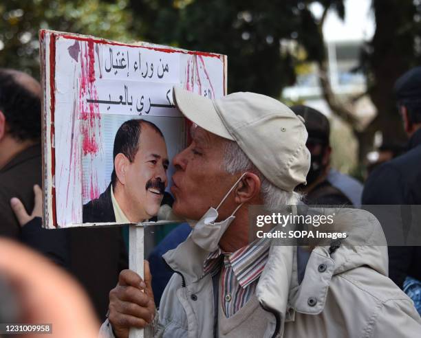 Protester kissing a Chokri Belaid portrait during a demonstration against government and police repression as they commemorate the 8th anniversary of...