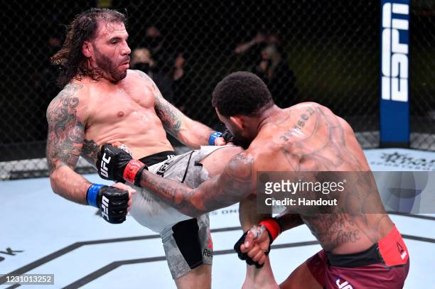 In this handout image provided by UFC, Clay Guida knees Michael Johnson in their lightweight fight during the UFC Fight Night event at UFC APEX on...