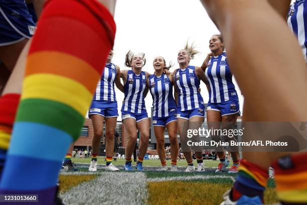 Mia King, Nicole Bresnehan, Daisy Bateman and Sophie Abbatangelo of the Kangaroos sing the team song during the 2021 AFLW Round 02 match between the...