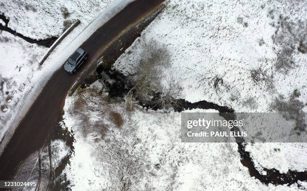 Car crosses a bridge over a stream near Kirkby Stephen in Cumbria, northwest England, on February 7, 2021. - Cold weather swept across northern...