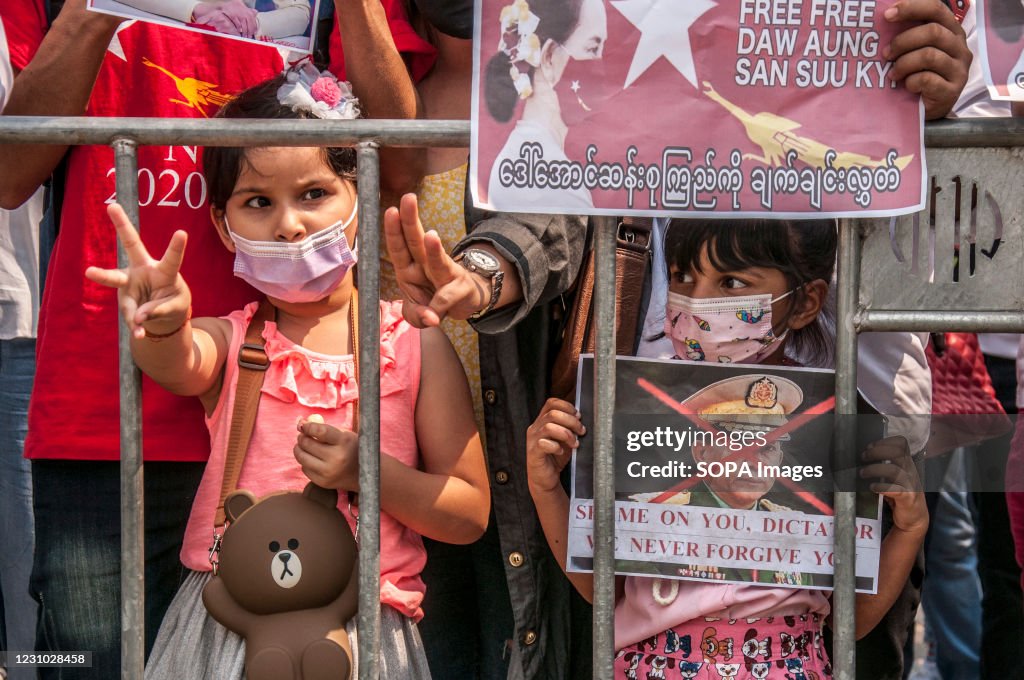 A girl makes the three finger salute during the...