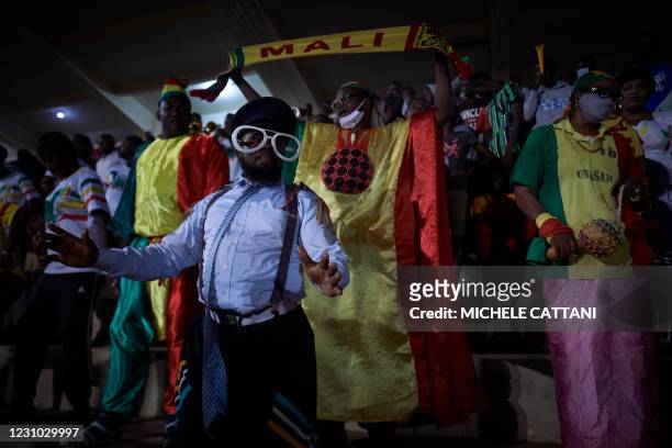 Supporter holds a flag of the Malian football team during the projection of the final match of the African Nations Championship between Mali and...