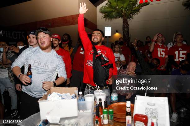 Tampa Bay Buccaneers and Kansas City Chiefs fans watch Super Bowl LV under the Wing House bar and grill watch party tent located near Raymond James...