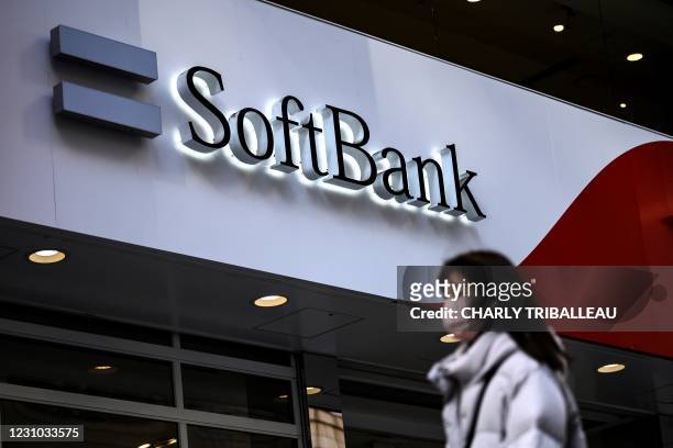 Pedestrian walks past the logo for telecom and investment giant SoftBank Group along a street in Tokyo on February 8 ahead of the company's earnings...
