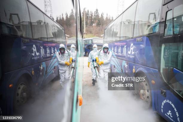 This photo taken on February 7, 2021 shows workers disinfecting a long distance bus station in Bijie, in China's southwest Guizhou province, as...