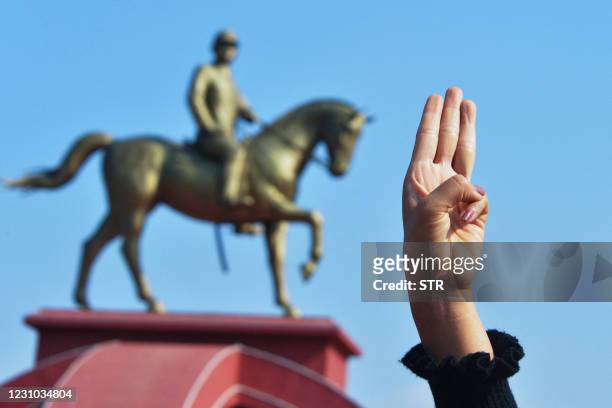 Protester holds up the three finger salute during a demonstration against the military coup at the monument of General Aung San , the late father of...