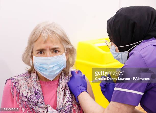 Maureen Mitson receives an injection of the the Oxford/AstraZeneca coronavirus vaccine from NHS nurse Maha Mutardi at the Elland Road vaccination...