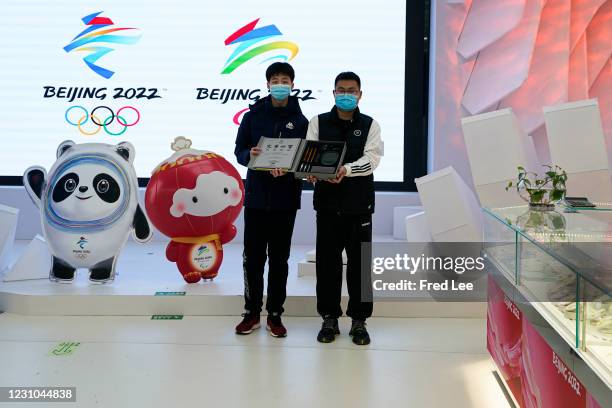 Visitors take a photo of the souvenirs at the Beijing 2022 licensed product flagship store on February 8, 2021 in Beijing.