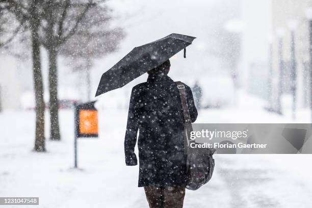 Man with umbrella is pictured during heavy snowfall on February 08, 2021 in Berlin, Germany. In the northern part of Germany there is heavy snowfall...