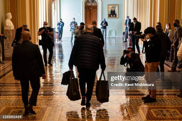 Senate Majority Leader Chuck Schumer arrives at the Senate side of the U.S. Capitol Building as a gaggle of press maneuvers around him on Monday,...