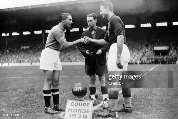 Italy's captain, Giuseppe Meazza shakes his hand with the Hungarian opponent, captain Gyorgy Sarosi under the eyes of French referee Georges...