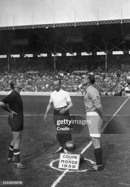 The two football team's captains, Giuseppe Meazza for Italy and Etienne Mattler for France, look up at the coin thrown by the referee to find out who...