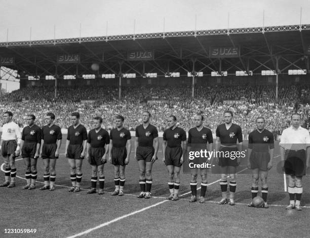 Giuseppe Meazza , captain, and the Italian football team listen to the national anthem before the match against Brasil on June 16, 1938 in Marseille...