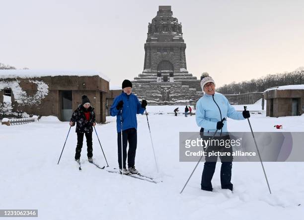 February 2021, Saxony, Leipzig: Steffi Hentze and the couple Rudolph and Martina Schneider are on cross-country skis in the snow in front of the...