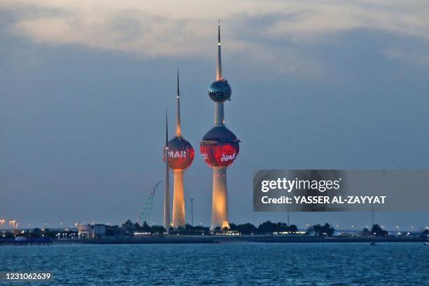 The Kuwait Towers are illuminated in red in Kuwait City to celebrate the UAE's "Hope" probe mission to Mars, on February 9, 2021.