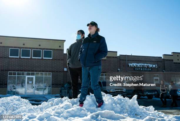 People look on from a parking lot adjacent to the Alina Health Clinic where a shooting took place on February 9, 2021 in Buffalo, Minnesota. Five...
