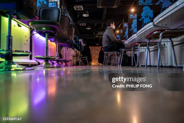 This picture taken on January 26, 2021 shows people playing games at the Mikado game centre in the Shinjuku district of Tokyo. - Bright, noisy game...