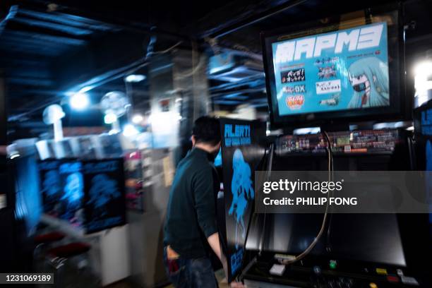 This picture taken on January 26, 2021 shows Yasushi Fukamachi, at the Mikado game centre, moving game machines after the centre closed early due to...