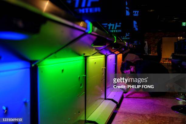This picture taken on January 26, 2021 shows Yasushi Fukamachi, a manager at the Mikado game centre, preparing to move arcade game machines as the...