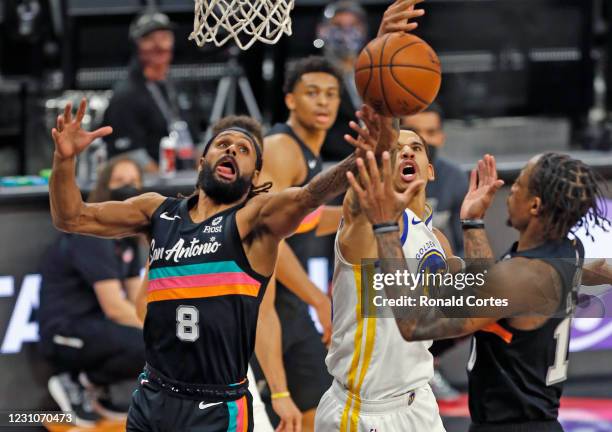 Patty Mills of the San Antonio Spurs battles for a rebound against the Golden State Warriors in the first half at AT&T Center on February 9, 2021 in...