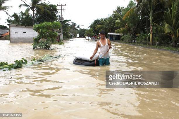 Villager makes his way along a flooded road in Karawang in West Java on February 10 after heavy rains inundated the areas along the Cibeet and...