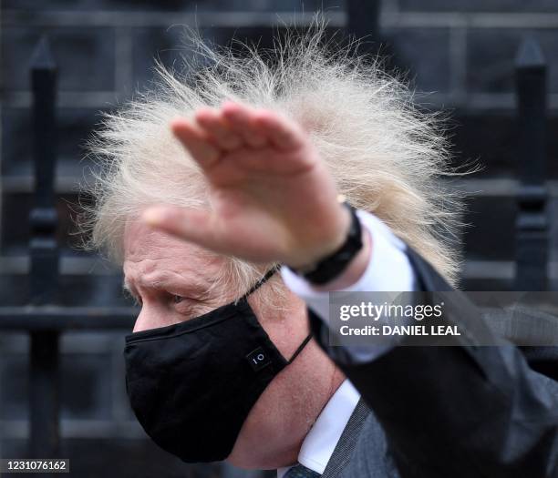 Britain's Prime Minister Boris Johnson, wearing a face covering, leaves 10 Downing Street in central London on February 10 to take part in the weekly...
