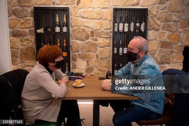 People wearing face masks sit inside a restaurant in the northern Spanish Basque city of San Sebastian on February 10, 2021 after the Basque Country...