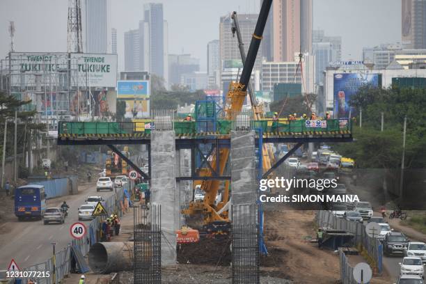 Motorists drive on Mombasa road, next to the ongoing construction of the Nairobi Expressway, undertaken by the Chinese contractor China Road and...