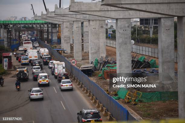 Motorist drive on Mombasa road, next to the ongoing construction site of the Nairobi Expressway, undertaken by the Chinese contractor China Road and...