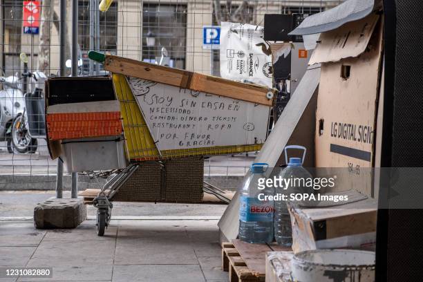 Cardboard boxes and a supermarket trolley are seen at the central commercial avenue of Passeig de Gràcia serving as a refuge for the homeless. The...