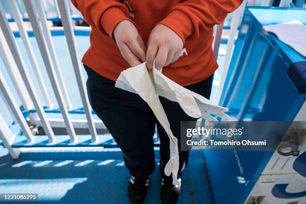 An employee wears gloves during a training session for employees held ahead of the reopening of the Hakkeijima Sea Paradise theme park on May 29,...