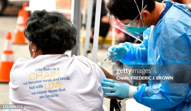 Registered Nurse Angelo Bautista administers the Moderna Covid-19 vaccine during a distribution of vaccines to seniors above the age of 65 who are...