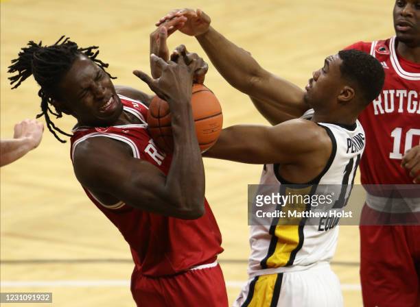 Guard Tony Perkins of the Iowa Hawkeyes battles for a rebound during the second half against center Cliff Omoruyi of the Rutgers Scarlet Knights at...